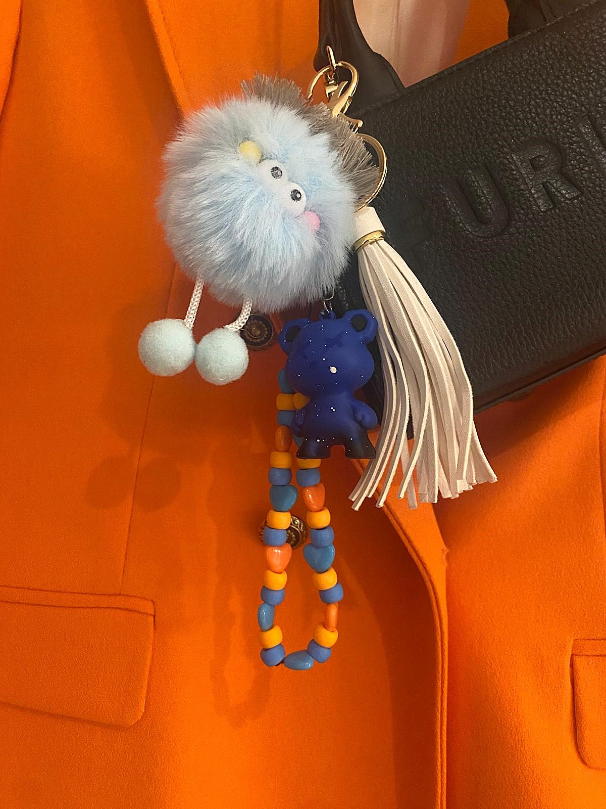 Cute and colorful keychain featuring a fluffy pom-pom character with googly eyes, a dangling bear charm, and a beaded strand. Perfect for adding a playful touch to your keys or bag.