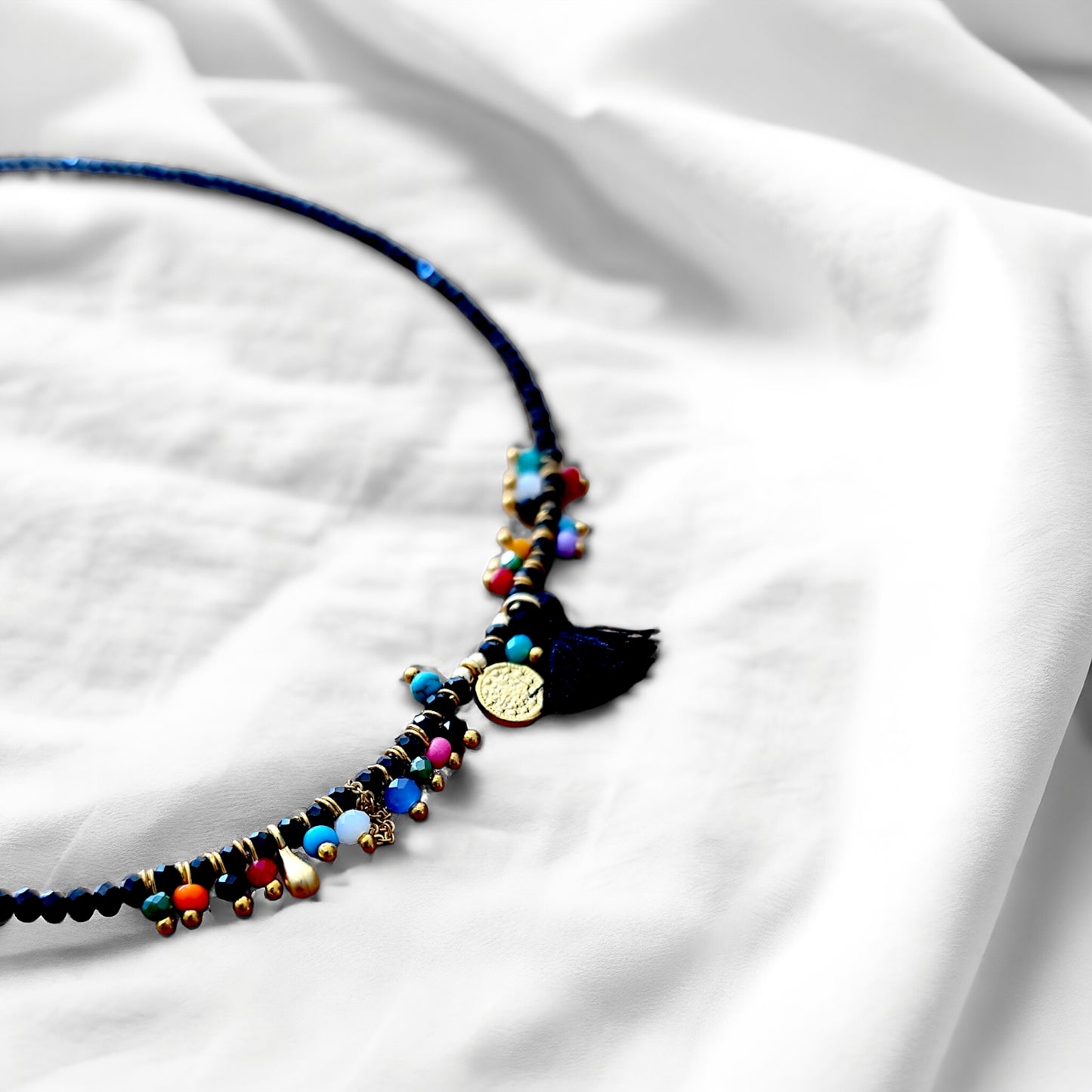 Close-up view of a black crystal costume necklace with a vibrant multicolore bead tassel, handcrafted with Arcobaleno beads.