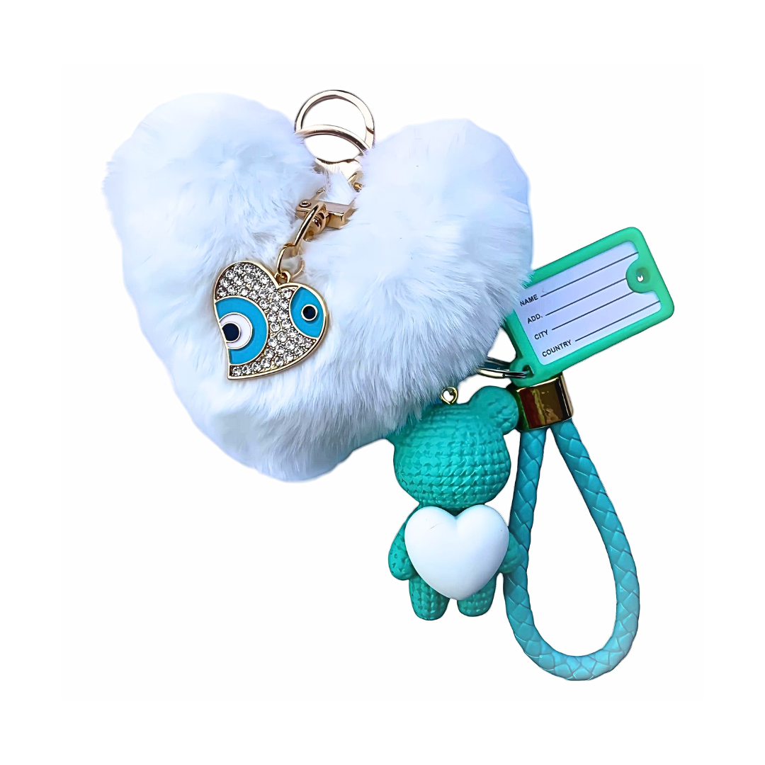 White heart-shaped keychain, faux fur pom-pom, evil eye charm, balloon dog, unique accessory, gift idea. Arcobaleno Beads heart keychain, stylish phone accessory, trendy design, boho chic. Buy now, blue heart keychain, add personality, cute accessory